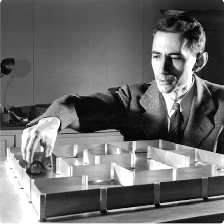 Claude Shannon placing robotic mouse in maze