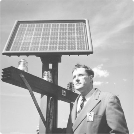 Man standing below pole-mounted solar collector
