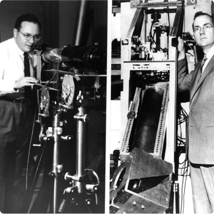 Two scientists in laboratory working on laser equipment