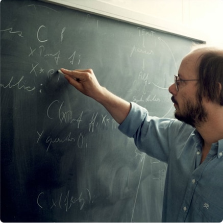 Man writing on blackboard in chalk