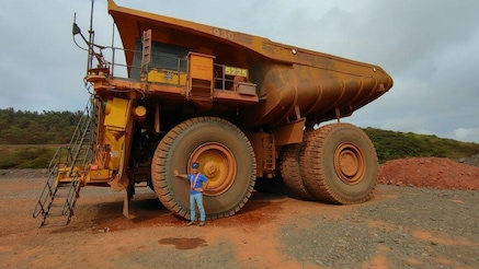 Lelio Di Martino, department head for Network Applications, standing in front of yellow mining tipper truck