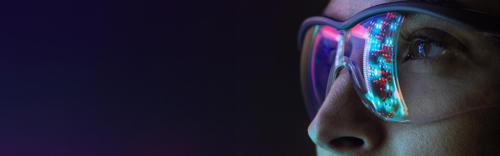 Woman wearing glasses in which a screen is reflected